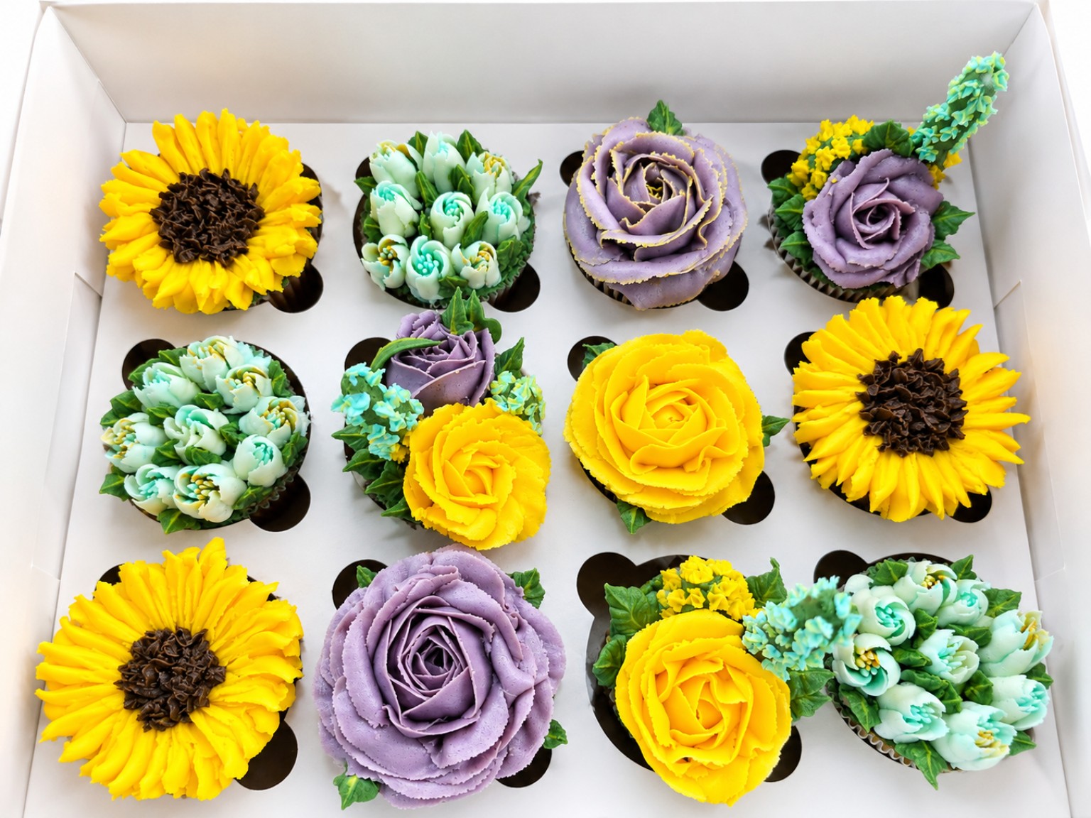 Twelve real sunflower, lavender rose and mint floral cupcakes presented in a white Boxed Blooms gift box