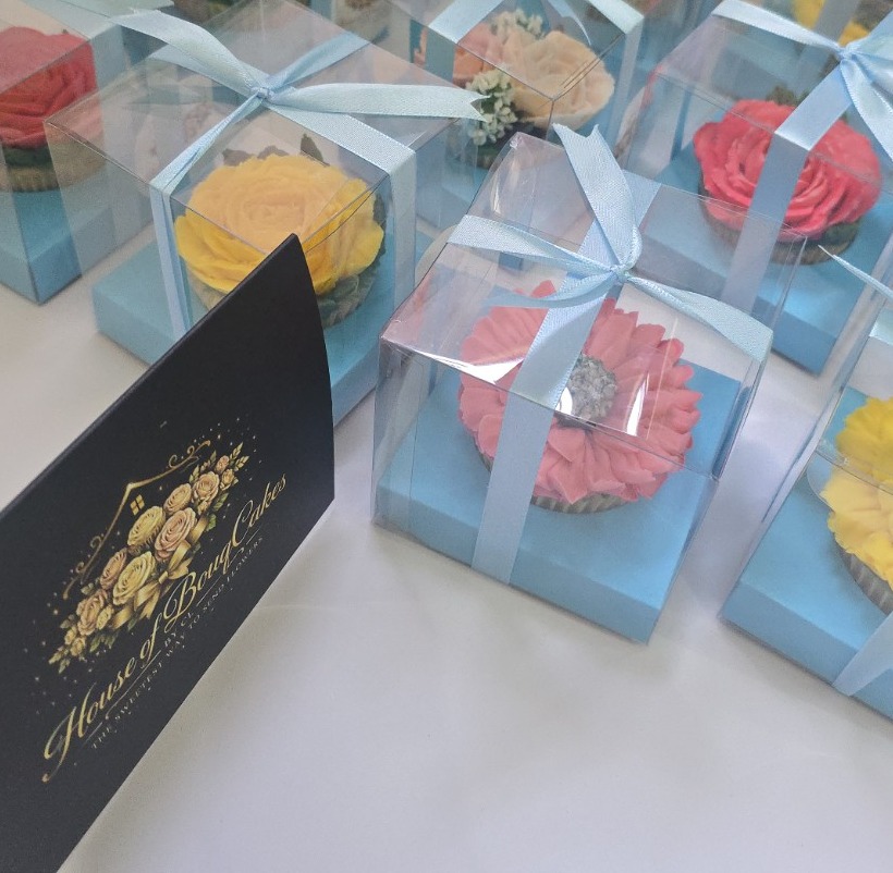 Real individually boxed floral cupcakes arranged for an event