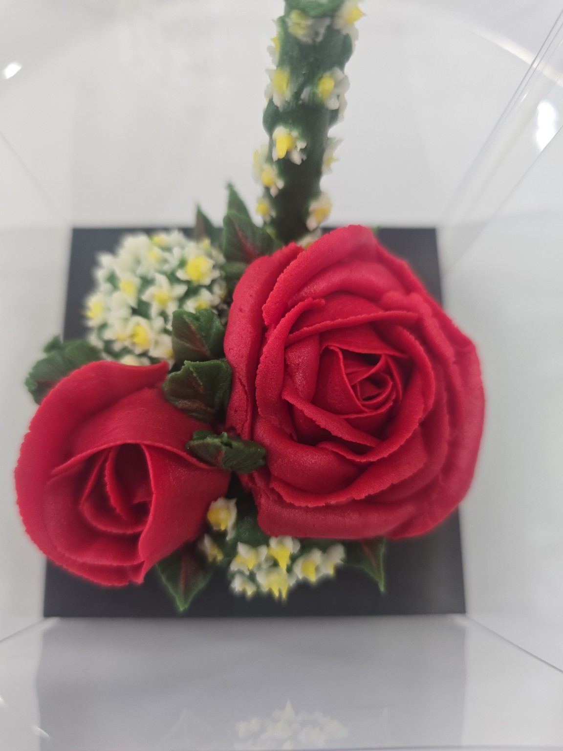 Hand-piped red buttercream roses with delicate floral details